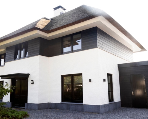 wit huis zwarte kozijnen rieten kap luxe